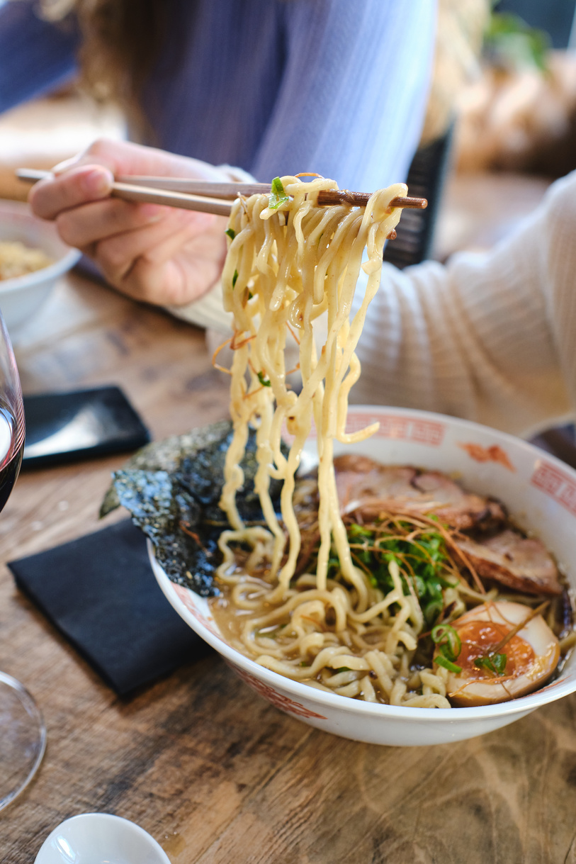 Faceless person eating delicious noodles with chopsticks